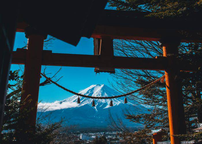 Mt. Fuji as seen through the red Torii gates of a shrine.